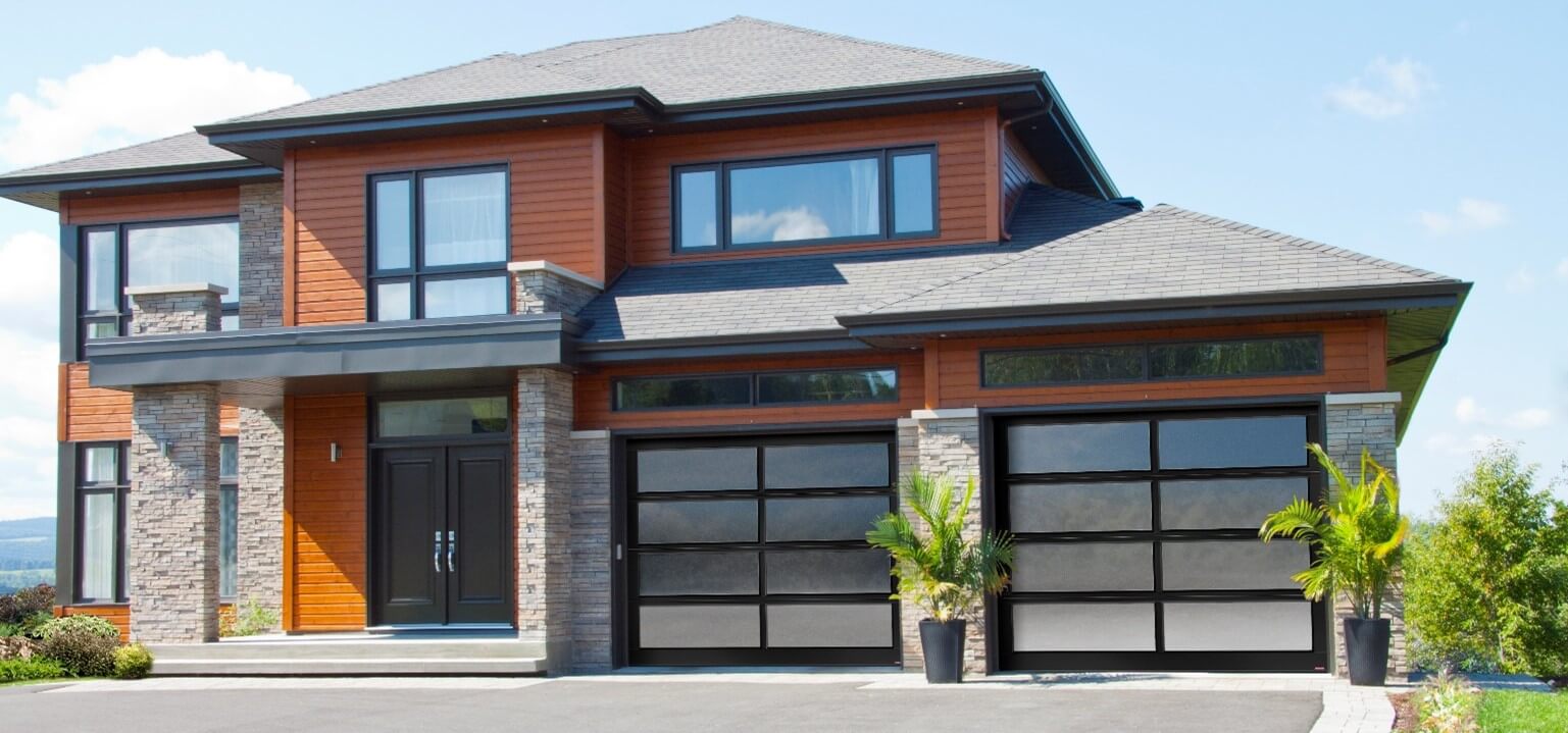 Gray-beige stone house, with burnt orange vinyl siding, combined with 2 California glass garage doors with White Sandblasted glass.